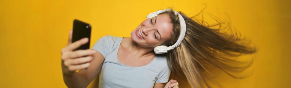 Mulher loira ouve músicas no fone de ouvido